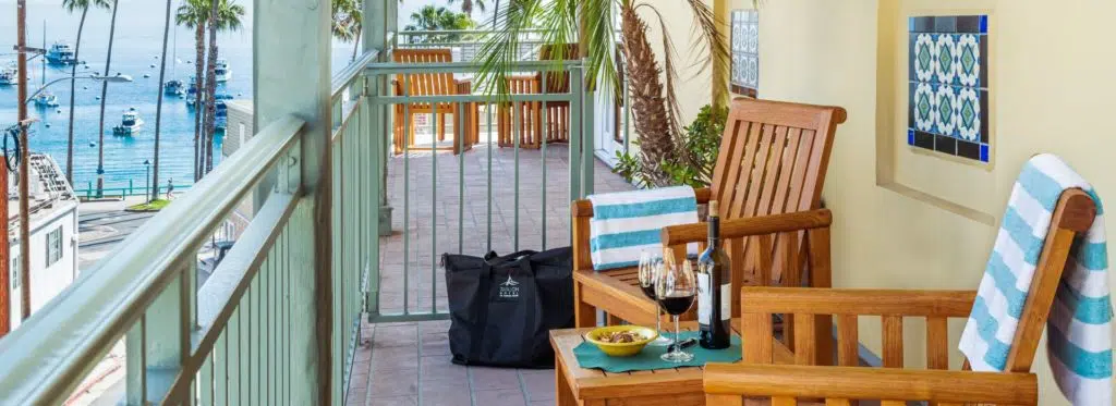 Balcony with wooden patio furniture and view of the harbor